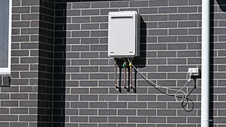Tankless water heater mounted on the exterior wall of a home