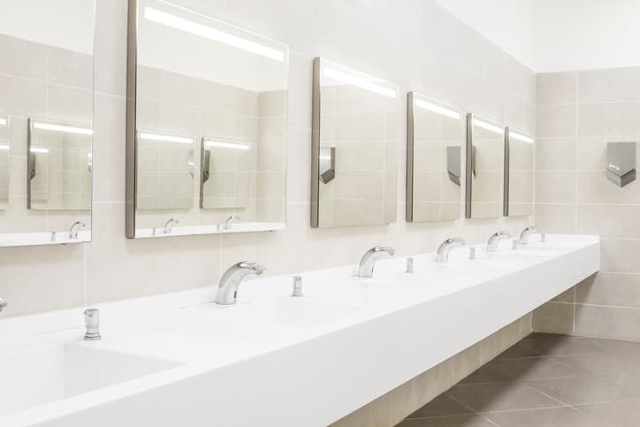 Modern commercial restroom with multiple sinks and wall mirrors