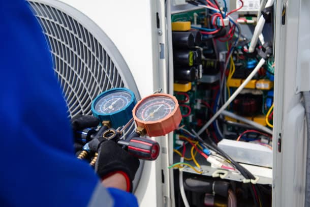 AC repair technician servicing an outdoor air conditioner in Edmonton